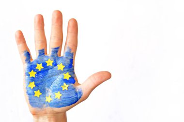 Bir kişi bulutlu bir gökyüzü önünde elini tutuyor , el sarı kağıt yıldız ile Avrupa Birliği renkleri ile boyanmıştır - kavram ab ve oy özgürlüğü kutlamak için