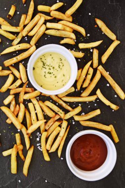  altın sarısı kızarmış taze patates kızartması , koyu mermer arka plan karşı, hangi patates kızartması ve tuz taneleri ve baharatlar yalan