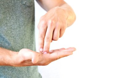 Genç bir adam avuçlarını gösterir - farklı ülkelerde farklı anlamlara sahip bir jest, adamın ellerine odaklanarak