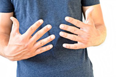 Genç bir adam boynuz parmakları gösterir - farklı ülkelerde farklı anlamları olan bir jest, adamın ellerine odaklanarak 