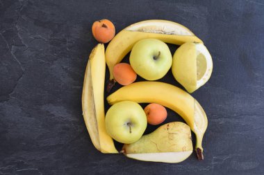 Elma, armut ve muz gibi sarı meyve bir demet düz bir yüzey üzerinde yalan, bir bıçak ile bir kare çerçeve meyve içine kesildi - mükemmel bir çerçeve olarak düzenlenmiş meyve