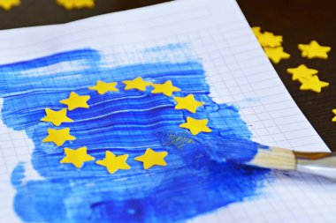 Bir fırça ve mavi boya ile, yanı sıra sarı kağıt yıldız yumruklu, Avrupa bayrağı bir blok levha üzerine çizildi - Avrupa kavramı ve Avrupa seçimleri maç için Avrupa birliği 