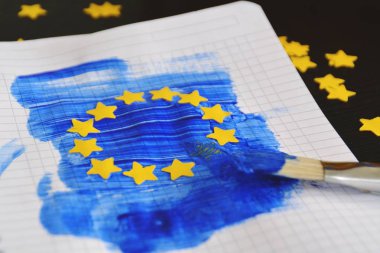 Bir fırça ve mavi boya ile, yanı sıra sarı kağıt yıldız yumruklu, Avrupa bayrağı bir blok levha üzerine çizildi - Avrupa kavramı ve Avrupa seçimleri maç için Avrupa birliği 