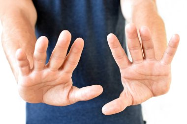 Genç bir adam avuçlarını gösterir - farklı ülkelerde farklı anlamlara sahip bir jest, adamın ellerine odaklanarak