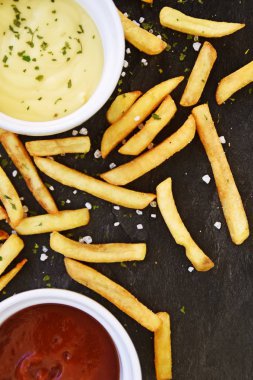  altın sarısı kızarmış taze patates kızartması , koyu mermer arka plan karşı, hangi patates kızartması ve tuz taneleri ve baharatlar yalan