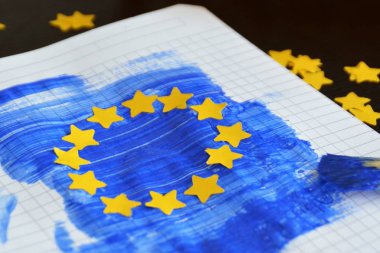 Bir fırça ve mavi boya ile, yanı sıra sarı kağıt yıldız yumruklu, Avrupa bayrağı bir blok levha üzerine çizildi - Avrupa kavramı ve Avrupa seçimleri maç için Avrupa birliği 