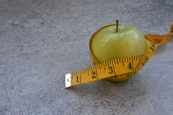 Una Cinta Métrica Amarilla Envolvió Alrededor Una Manzana Concepto Para —  Fotos de Stock