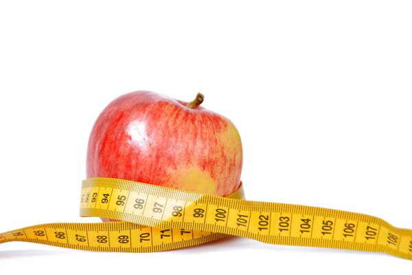 A yellow measuring tape was wrapped around an apple, concept for dieting and slimming due to health with space for text or other elements