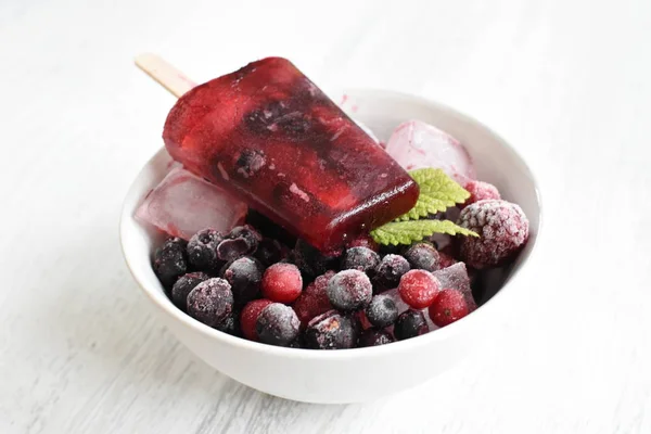Homemade popsicles of wild berries with berries and mint leaves - refreshing healthy organic ice