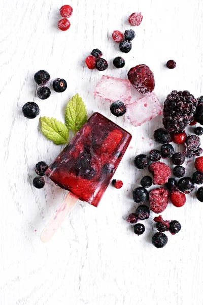 Homemade popsicles of wild berries with berries and mint leaves - refreshing healthy organic ice