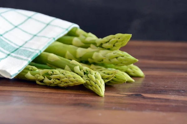 Een Heleboel Verse Groene Ongekookte Asperges Staat Een Donker Houten — Stockfoto