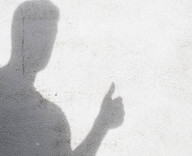 beyaz duvara başparmak gesturing adam gölgesi