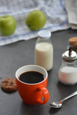 Masadaki turuncu fincanda kahve. 