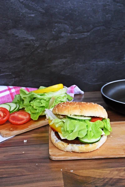 tasty big burger on chopping board at kitchen table