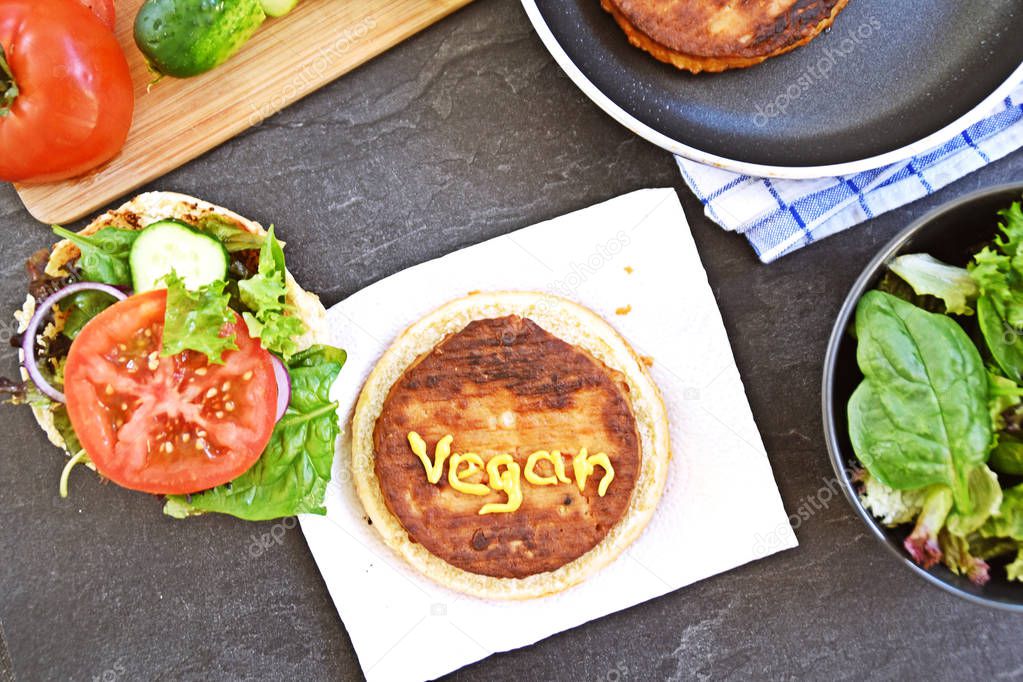 vegan burger preparation on chopping board at kitchen table
