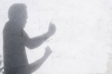 beyaz duvarda mücadele gesturing adam gölgesi