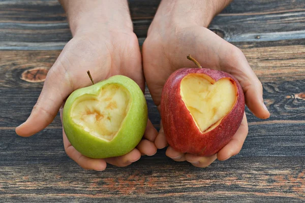 Holding apple with a heart shape cut out in the hand