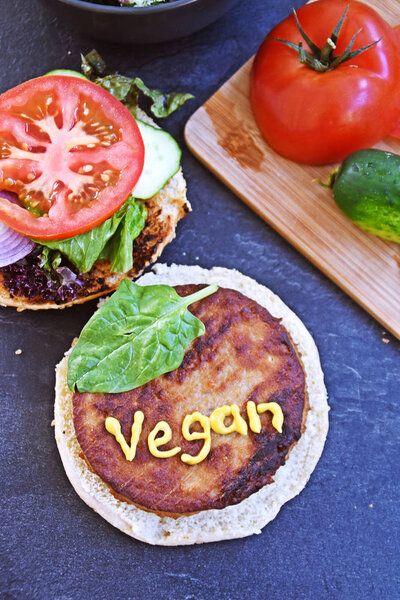 vegan burger preparation on chopping board at kitchen table