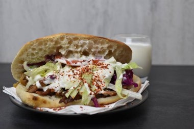 Almanya 'dan gelen lezzetli, taze kebap, ayran ve acılı baharatların yanında ahşap bir yüzeyde. Almanya' dan almak için popüler bir kebap.