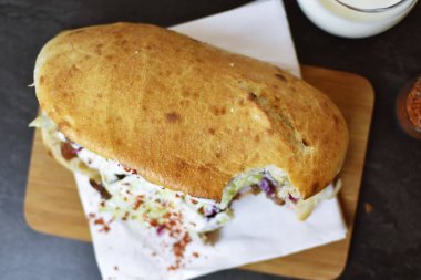 Almanya 'dan gelen lezzetli, taze kebap, ayran ve acılı baharatların yanında ahşap bir yüzeyde. Almanya' dan almak için popüler bir kebap.