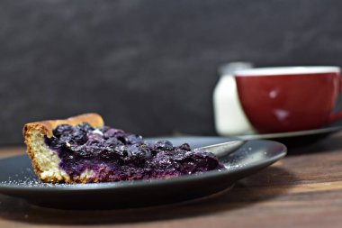 Koyu arkaplanda taze reçelli yabanmersinli tart.