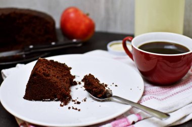 Açık renkli bir tabakta ev yapımı çikolatalı kek. Lezzetli, sütlü ve kahveli kek. Öğleden sonra kahvesi için.