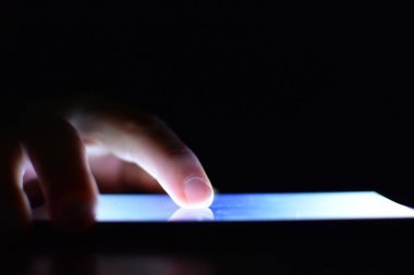 Karanlıkta aydınlatma ekranı olan akıllı telefon kullanan kişinin kısmi görüntüsü