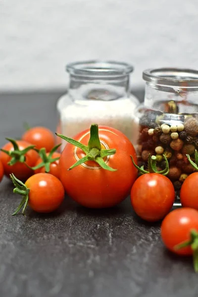 Tomates Frescos Sal Granos Pimienta Frascos Vidrio Sobre Fondo Gris — Foto de Stock