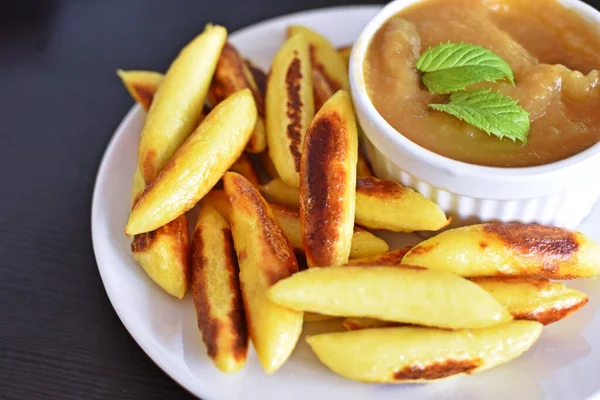 Delicious, fried Schupfnudeln from Germany covered with icing sugar next to a bowl of apple sauce. Delicious dessert as a sweet lunch in Germany