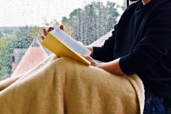 Adam Pencere Pervazında Oturuyor Pencere Kenarındaki Yağmur Damlalarında Kitap Okuyor — Stok fotoğraf