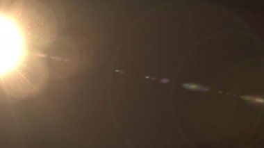 Doğal mercek parlaması. Siyah Arka Plan üzerinde Lens Flare ışık. Video nun üzerine bindirme veya ekran filtresi eklemesi kolaydır. Sıcak parlama etkisi. Uzayda güneş ışığı 4k çözünürlükte 