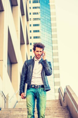 Sakallı, dizüstü bilgisayar, taşıyan kol genç profesyonel ailesine onun cep telefonu üzerinde konuşurken merdivenlerden inip ofis binası çalıştıktan sonra eve gitmek dışında yürüyüş. Filtre uygulanmış görünüm.