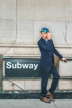 Şık şapka işareti Nyc - New York City, mavi takım, kahverengi çizme ayakkabı, Metro İstasyonu tarafından ayakta, etrafa, sizi sakallı genç bir adam. Filtre uygulanmış etkisi