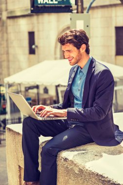 Avrupa seyahat, New York'ta çalışan iş adamı. Mavi takım elbiseli Giydirme, sakallı, sokakta oturan genç bir adam gülümseyerek, okuma, yazarak, dizüstü bilgisayarda çalışarak. Filtre uygulanmış etkisi.