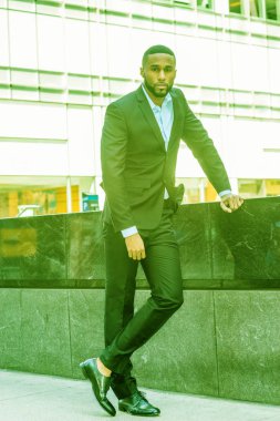 Sakallı genç Afrikalı-Amerikalı adam New York'ta giymiş siyah ceket, pantolon, deri ayakkabı, etrafa Manhattan Middletown, sokakta duran seyahat. Renk Ufo yeşil göz filtre