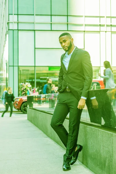 Sakallı genç Afrikalı-Amerikalı adam New York'ta giymiş siyah ceket, pantolon, deri ayakkabı, etrafa Manhattan Middletown, sokakta duran seyahat. Renk Ufo yeşil göz filtre