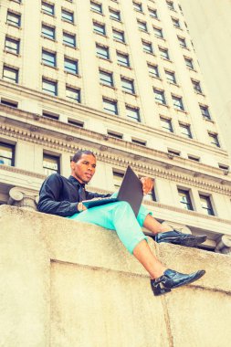 New York'ta sokakta çalışan ABD'li iş adamı. İş bölgesinde siting, okuma, dizüstü bilgisayar üzerinde çalışan genç sert siyah adam. Teknolojisinin gücü. Modern yaşam.