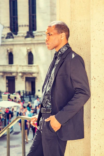 Serious African American businessman with scar on his head, standing on street in New York, thinking. Concept of facing tough reality, up and down, self assured, self esteem, confidence and success