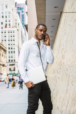 New York, Manhattan, sokakta yürürken dizüstü bilgisayar, taşıyan beyaz gömlek giymiş seyahat genç Afrikalı-Amerikalı işadamı cep telefonuyla konuşan sakallı dinleme, ciddi ciddi düşünüyorum