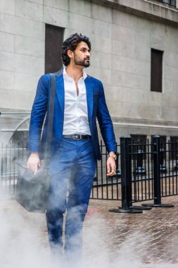 Yağmur gün - grenli, sisli, ıslak hissediyorum. Sakallı genç Doğu Hint Amerikalı İş Adamı, mavi takım elbise, beyaz gömlek giyiyor, deri omuz çantası taşıyor, uzağa bakıyor, New York'ta sokakta yürüyor