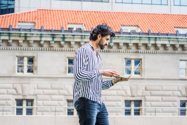 Yağmur - grenli, yağmurlu, ıslak hissediyorum. Sakallı, siyah, beyaz çizgili gömlek giyen, New York'ta ofis binasının önünde duran, dizüstü bilgisayarda çalışan genç Doğu Hint Asıllı Amerikalı işadamı