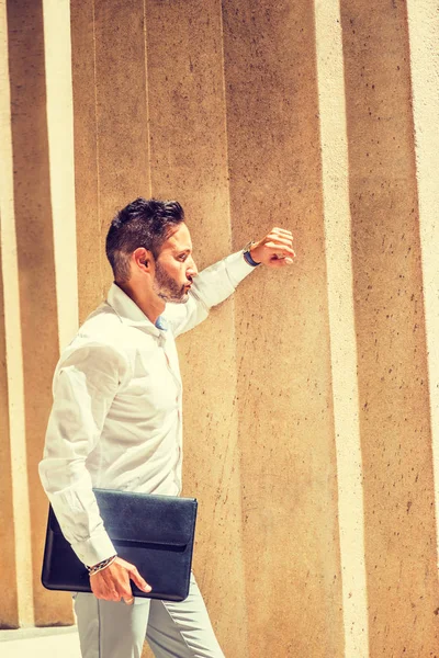 Dışarıyı düşünüyorum. Sakallı, beyaz tişörtlü, evrak çantalı genç Avrupalı iş adamı New York 'ta ofisin dışında güneş ışığı altında duruyor, kolları üzerinde dinleniyor, düşünüyor. Yan Görünüm