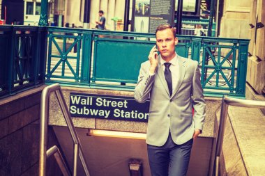 New York 'ta gezen genç adam, gri ceketli, beyaz gömlekli, siyah kravatlı, merdivenlerden çıkan, Wall Street' teki metro istasyonundan çıkan, cep telefonuyla konuşan. Retro filtrelenmiş tuvalet