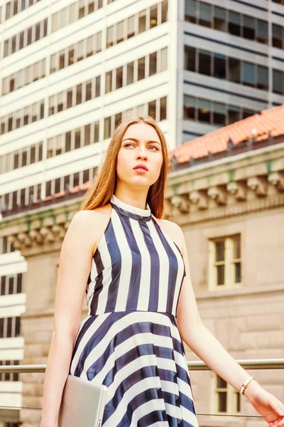 ヨーロッパの大学生の旅行 ニューヨークでの勉強 ノースリーブ 黒と白のストライプのドレスを着て ラップトップコンピュータを保持し 高い建物で通りを歩いて 楽しみにしています — ストック写真