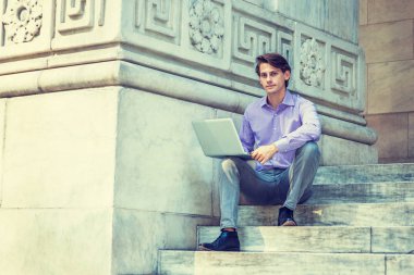 Genç yakışıklı iş adamı New Yo 'da bilgisayarda çalışıyor.