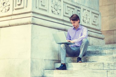 Genç yakışıklı iş adamı New Yo 'da bilgisayarda çalışıyor.