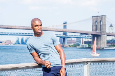 Seni özlüyorum, seni bekliyorum. New York 'ta gezen, gri tişörtlü, East River' ın yanında dikilen genç bir Afro-Amerikan. Manhattan ve Brooklyn köprüleri arka planda