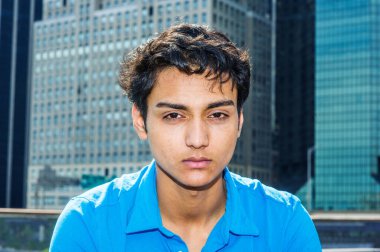 New York 'ta 18 yaşındaki Doğu Hintli Amerikalı bir gencin portresi. Mavi gömlekli genç bir üniversite öğrencisi, dışarıda oturmuş düşünüyor. Arka plandaki yüksek binalar. Yaklaş, Müdür Sho.
