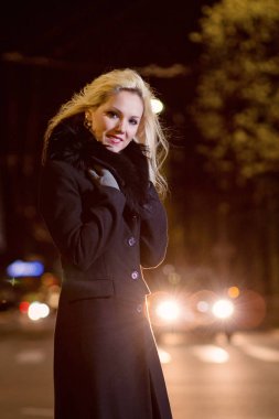 Güzel, sarışın bir kadın araba ışıklar gece şehrin içinde.