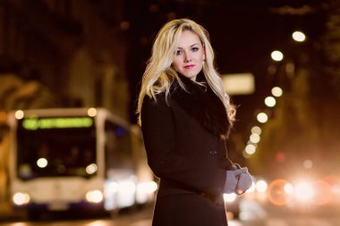 Güzel, sarışın bir kadın araba ışıklar gece şehrin içinde.